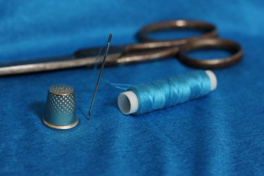 Mavi İplik, Yüksük ve Şırınga Mavi Kumaşta Arka planda Eski Makas