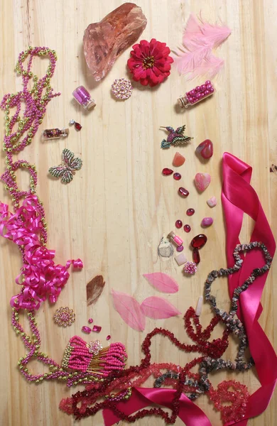 Pink and Magenta Jewelry With Flower on Wood Table. Top View