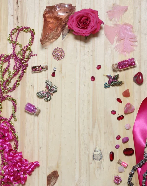 Pink and Magenta Jewelry With Flower on Wood Table. Top View