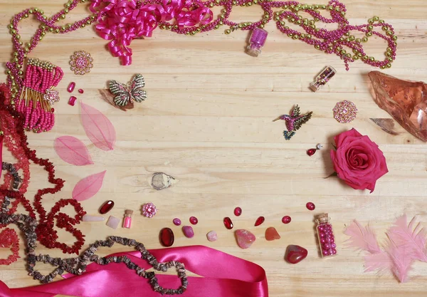 Pink and Magenta Jewelry With Flower on Wood Table. Top View