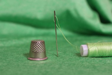 Yeşil İplik, Yüksük ve İğne Makarnası Yeşil Kumaşa Yaklaş