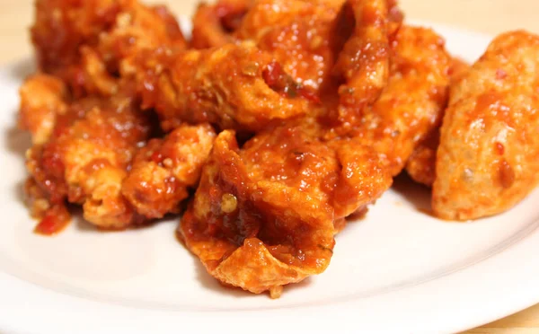 Fried Pork Skins With Red Salsa on Wooden Table in Rustic Kitchen