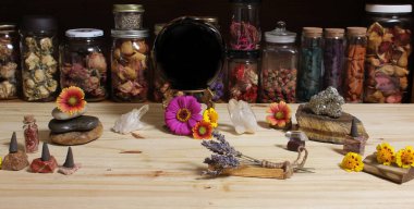 Meditation Altar With Rock Crystals and Flowers. Large Obsidian Crystal Ball in Center Jars of Herbs in Background