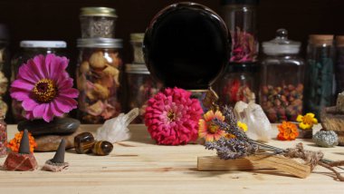 Meditation Altar With Rock Crystals and Flowers. Large Obsidian Crystal Ball in Center Jars of Herbs in Background