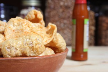 Fried Pork Rinds With Hot Sauce in Rustic Kitchen
