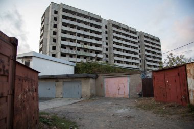 VLADIVOSTOK, RUSSIA - 03 / 09 / 2021 Bir Sovyet terk edilmemiş, balkonlu beton ev binası ve önünde Rusça ve eski kırmızı garajlarda seni seviyoruz yazan bir yazı.
