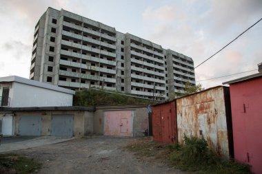 VLADIVOSTOK, RUSSIA - 03 / 09 / 2021 Bir Sovyet terk edilmemiş, balkonlu beton ev binası ve önünde Rusça ve eski kırmızı garajlarda seni seviyoruz yazan bir yazı.