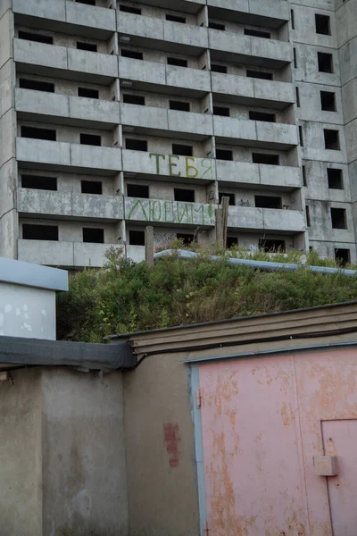 俄克拉荷马州Vladivostok 2021年9月3日一座废弃的 废弃的 未完成的 闹鬼的 有阳台的 我们爱你 位于前面的俄罗斯和红色旧车库的住宅建筑 — 图库照片
