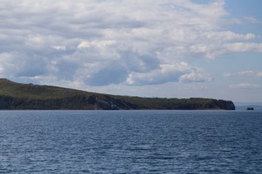 Rusya 'nın Vladivostok adasındaki Russky adasındaki Novik limanında deniz manzarası, adalar, pelerinler, beyaz bulutlar ve mavi gökyüzü