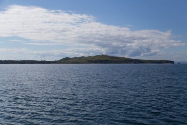 Rusya 'nın Vladivostok adasındaki Russky adasındaki Novik limanında deniz manzarası, adalar, pelerinler, beyaz bulutlar ve mavi gökyüzü