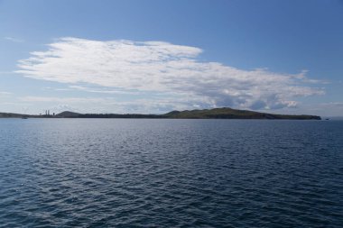 Rusya 'nın Vladivostok adasındaki Russky adasındaki Novik limanında deniz manzarası, adalar, pelerinler, beyaz bulutlar ve mavi gökyüzü