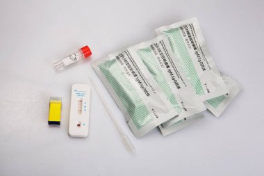 Negatif bir sonucun izole edilmiş görüntüsü hızlı bir şekilde antijen antikor koronavirüs covid-19 pandemik test örneği, kan koleksiyoncusu pastet, karaciğer tüpü, solüsyon, beyaz arka plandaki paketler.