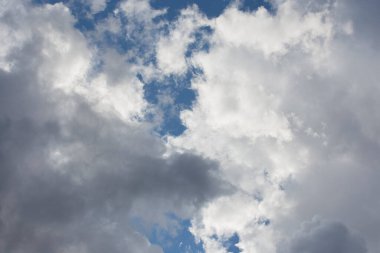 Pofuduk, dramatik, beyaz ve gri bulutların altında derin mavi bir arka planda güzel bir gün bulutlu manzarası.