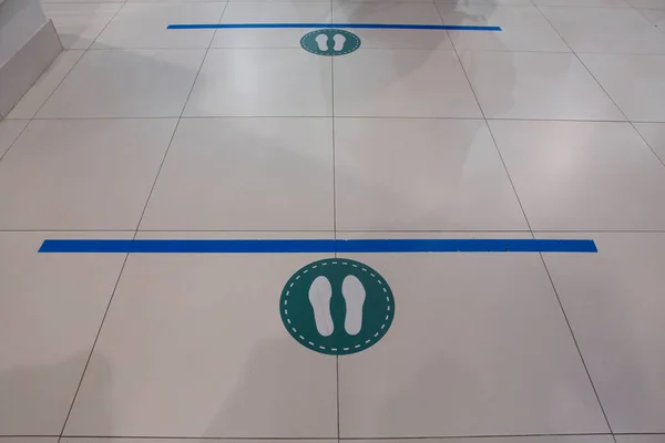 social distancing, keep the distance prevention floor sticker sign with two meters blue line, footsteps circle for queues in a mall shop