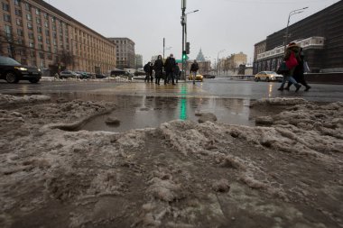 MOSCOW, RUSSIA 23.01.2021 kirli, siyah, ıslak, ıslak, erimiş kar, çamur ve sızıntı, asfalt yoldaki büyük su birikintisi. İnsanlar yaya geçidinden geçiyorlar. İç karartıcı kış buzları. Maykovskaya Meydanı