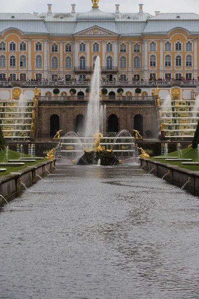 Peterhof Saint Petersburg ロシア 2021グランドカスケードとサムソン噴水黄金の彫刻と路地の水の運河を設立 曇った灰色の空の日の垂直ショットの背景に宮殿 — ストック写真