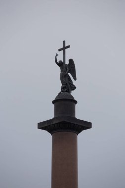 Saint Petersburg, Rusya - 12.08.2021 Alexander Sütunu, saray meydanının altında haç ve yılan tutan melek heykelini tasvir ediyor. Gri bulutlarda dikey yaklaşma 