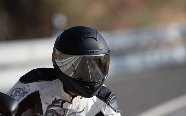 黒いヘルメットと革のジャケットを持つバイカーの女性は 彼女のロードバイクの上に実行されます 集中力のない背景 — ストック写真