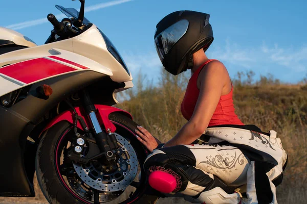 若い女性はバイクの前の車輪に身を包んだ安全ヘルメットを身に着けて — ストック写真