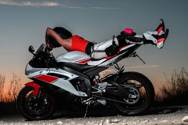 Сексуальна Молода Жінка Лежить Спині Дорозі Мотоцикл Одягнений Захисні Штани — стокове фото