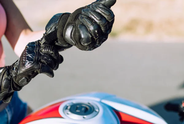 バイクに乗るために革の保護手袋をはめた若いバイカーの女性の手の詳細 — ストック写真
