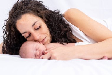 Yatakta yatarken yeni doğmuş bebeğine bakan bir annenin portresi. konsept aile, ilgi ve yeni doğan bebeğe bakma