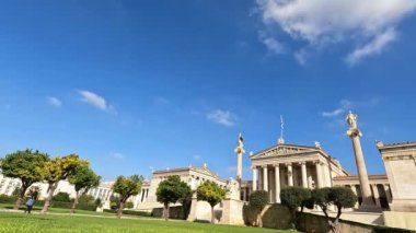 Atina, Yunanistan-4 Kasım 2021. 4k hızlandırılmış video, arka planda mavi gökyüzü olan güneşli bir günde Atina Akademisi 'nin dışındaki insanları gösteriyor..