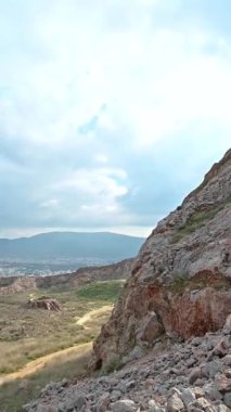 Dikey yönelimli HD görüntüleri, bulutlu bir günde tepenin kenarından Atina-Yunanistan şehrini gösteriyor.
