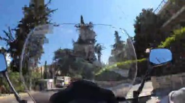 Athens, Greece-August 12 ,2022.Pov time wrap footage of a person driving his scooter in the streets of Athens on a sunny day.