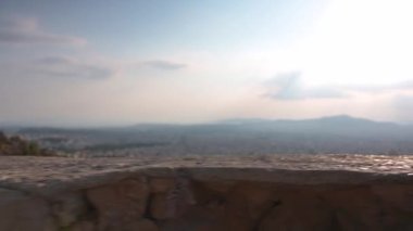 Camera movement behind a stone wall reveals a part of Athens city -Greece from high angle