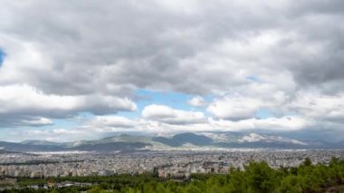 Hareketli zaman aşımı videosu, Atina-Yunanistan kentindeki bir tepenin yakınından geçen bulutları gösteriyor.