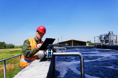 Worker inspecting valve for filtering water clipart