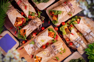 farklı çeşitte tavuk dürümleri ya da ahşap plaka ve siyah arka plan. Kopya çizelgesi..