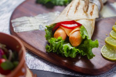 Taze domatesli, salatalı, peynirli ve soğanlı taze sosisli börek. Yan görünüm. Uzaya bak. Seçici odak