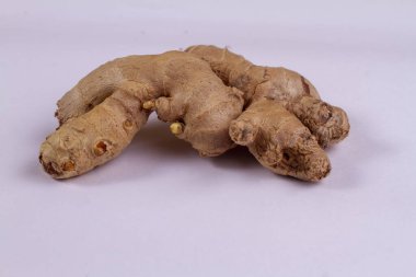 Dilimlenmiş yeşil yapraklı taze zencefilli rizom beyaz arkaplanda izole edilmiş..