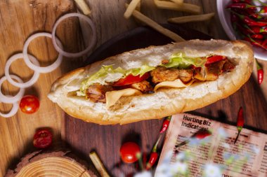 Tavuklu tikka dürümü, domates sosu ve ahşap arka planda Arap sokak yemeklerinin en üst görüntüsünü iç.