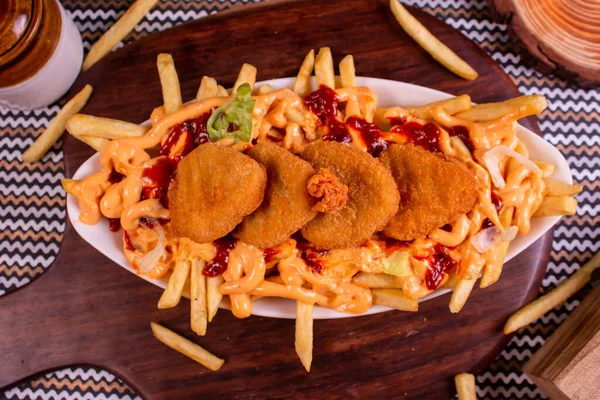 Dish of CHEESY NUGGET FRIES at cafe restaurant. American fast food dish, consisting of french fries covered in cheese.