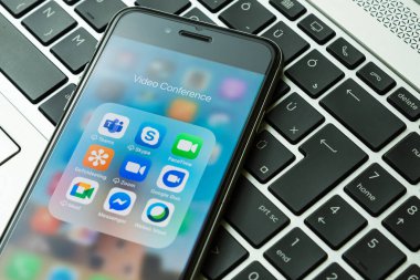 Gyor, Macaristan - 19 Mayıs 2021: Zoom 'un mobil uygulama simgeleri, Microsoft Takımları, FaceTime, Skype, Messenger, Google Duo, GoToMeeting, Google Meet ve Webex Meet iPhone' da görülmektedir. Arka planda dizüstü bilgisayar.