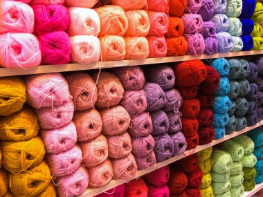 Örgü işi el işi konsepti. Sanat ve zanaat dükkanındaki raflarda örgü örmek için parlak renkli yün yumakları..
