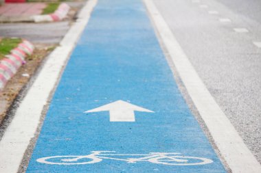 Mavi asfalttaki bisiklet trafik levhası sadece bisikletçilerin güvenliği için kullanılabileceğini gösteren bir yol işaretidir. Yol kullanıcıları için güvenlik işaretleri oluşturma kavramı.