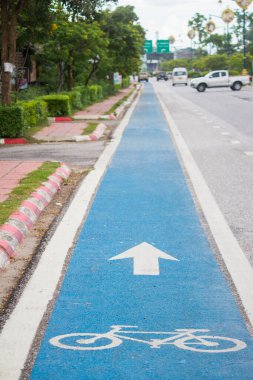 Mavi asfalttaki bisiklet trafik levhası sadece bisikletçilerin güvenliği için kullanılabileceğini gösteren bir yol işaretidir. Yol kullanıcıları için güvenlik işaretleri oluşturma kavramı.