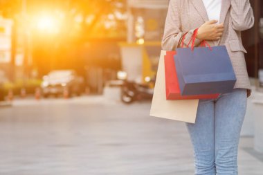 Bulanık bir görüntü, alışveriş poşeti tutan genç bir kadın bir mağazada indirimli ürünler için alışverişe çıktıktan sonra yeni yıl tatili yaklaşırken, indirimde olan bir promosyon var. alışveriş kavramı