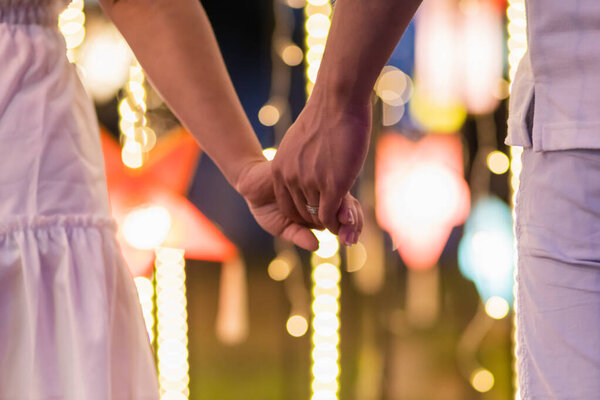 Blur image,couples walking hand in hand along the corridor To see the beautiful scenery of the festive lights happily and her lover wants to say love and propose to her girlfriend on Valentine's Day.