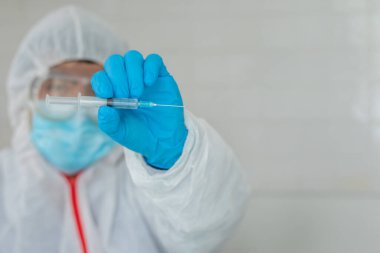 Doktor ekibi Corona virüsü Covid 19 'un kirlettiği biyolojik tüpleri incelemek ve Covid' i önlemek için aşı araştırması yapmak için koronavirüs koruyucu giysisi ve lastik eldiven giymişti.