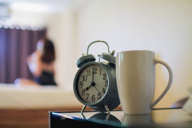 Yatağın yanına yerleştirilmiş Yumuşak Odaklanma ve Yumuşak Odaklı Alarm Saati kadınların uyanma ve işe zamanında gitmeye hazırlanmaları için belirlenen saatte uyandı. Alarmı bir çalar saat kullanarak kurma fikri