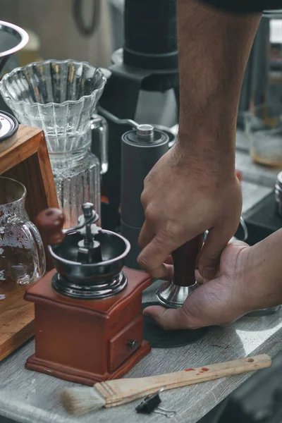 young barista is showing drip method and procedure with equipment placed on coffee table to customers who are ordering  drip coffee. Young barista shows how to drip coffee while camping