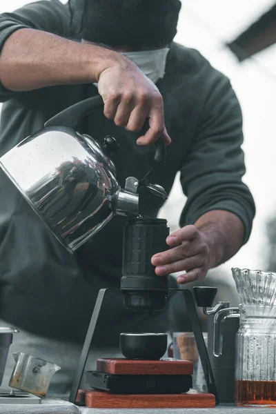 young barista is showing drip method and procedure with equipment placed on coffee table to customers who are ordering  drip coffee. Young barista shows how to drip coffee while camping