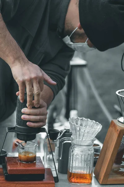 young barista is showing drip method and procedure with equipment placed on coffee table to customers who are ordering  drip coffee. Young barista shows how to drip coffee while camping