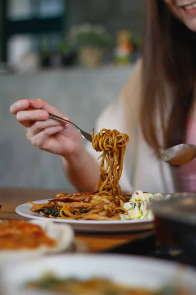亚洲女人在餐馆里吃意大利面和辣海鲜酱汁 辣味海鲜意大利面放在盘子里 按照这位女士的吩咐放在饭桌上 — 图库照片