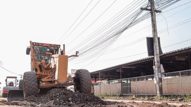 Chiang Mai Thai 23 December 2021 Construction workers are adjusting road surface with heavy machinery to achieve smooth surface and compact ground before pouring reinforced concrete give road strength